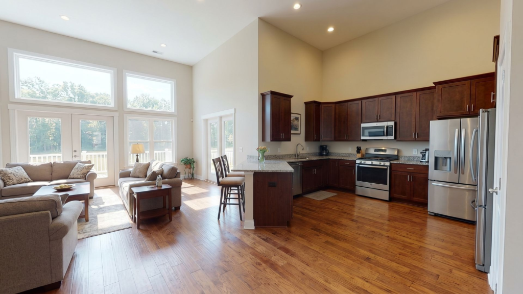 An L-shaped open concept living room and kitchen layout that maximizes space in a modern open floor plan.